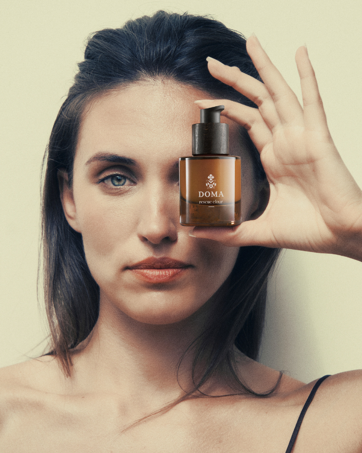Woman applying DOMA Rescue Elixir as part of her morning skincare routine