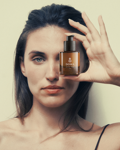 Woman applying DOMA Rescue Elixir as part of her morning skincare routine