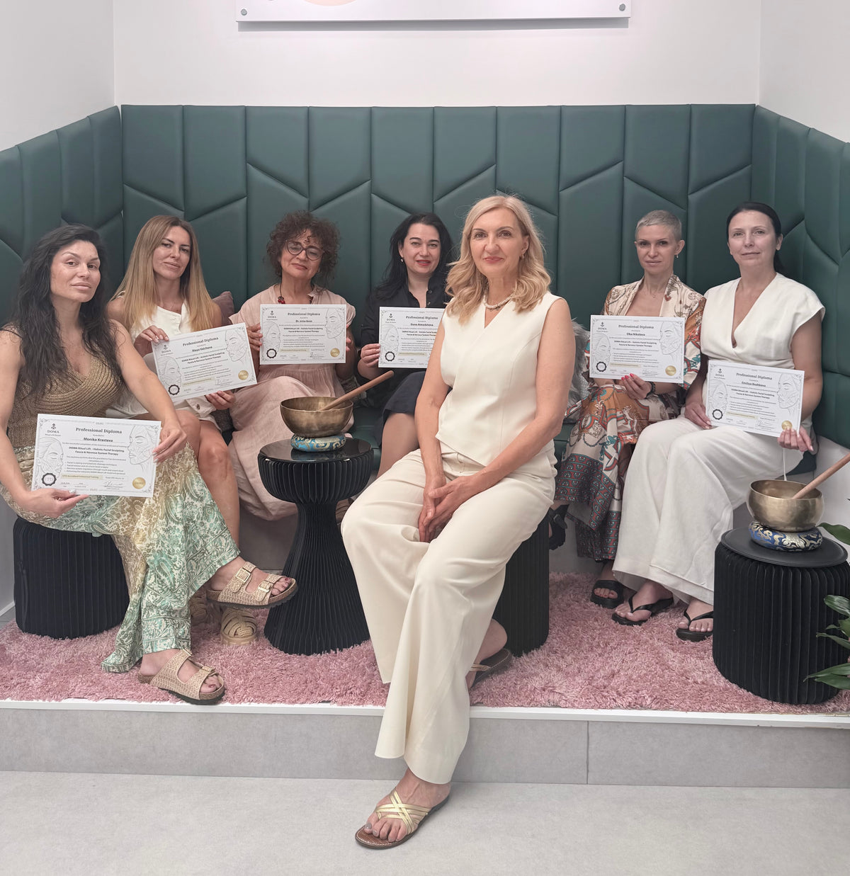 Founder Donna Maneva with DOMA Ritual Lift graduates holding their CPD-accredited diplomas, beside Himalayan singing bowls