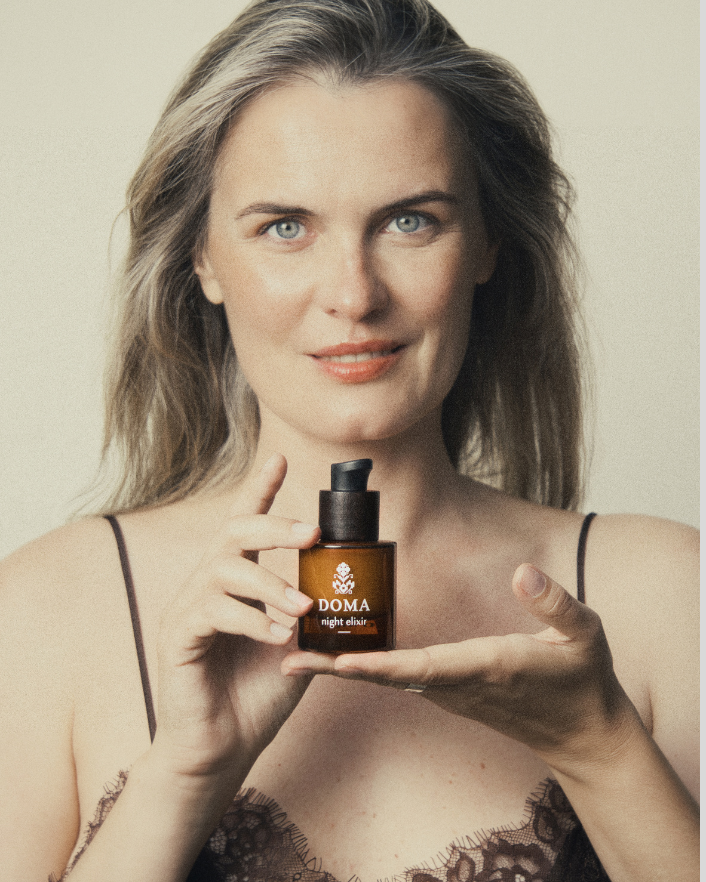 Woman applying DOMA Night Elixir as part of her evening skincare ritual