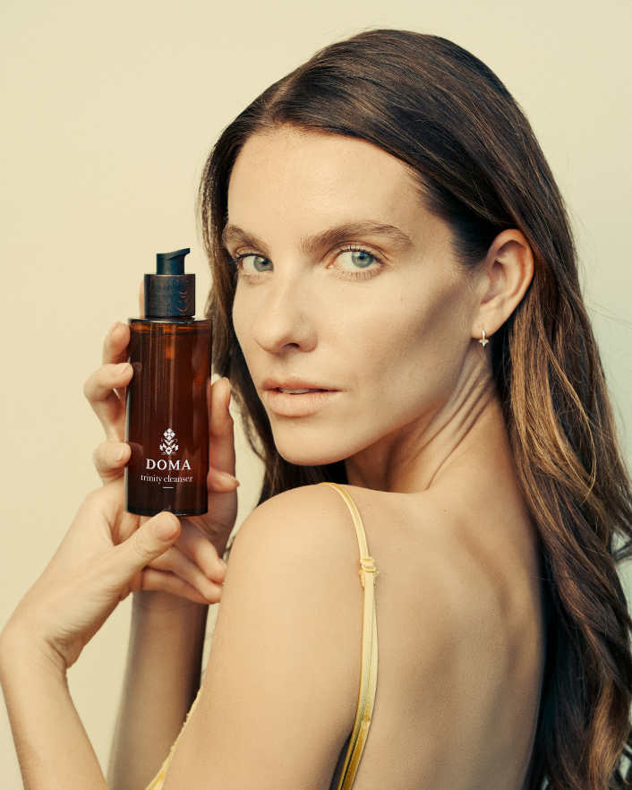 Woman using DOMA Trinity Cleanser as a face mask