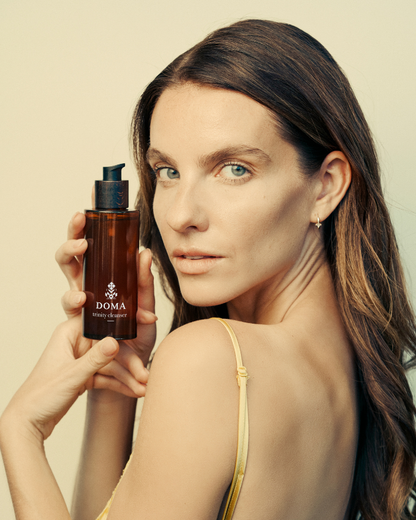 Woman using DOMA Trinity Cleanser as a face mask